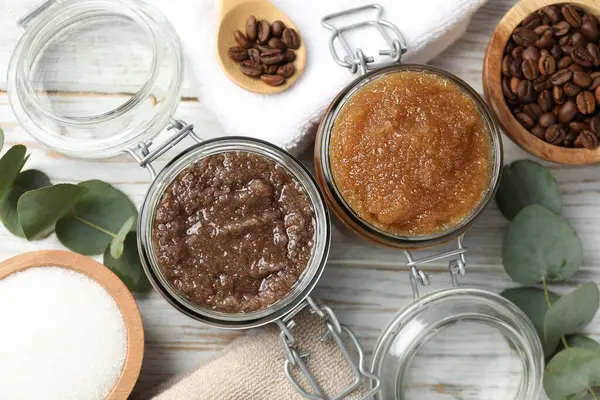 Cam kavanozlarda doğal vücut önlükleri ve ahşap masa üzerindeki malzemeler.