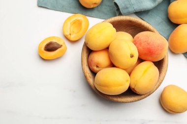 Taze kayısılar beyaz mermer masada kasede, düz yerde. Metin için boşluk