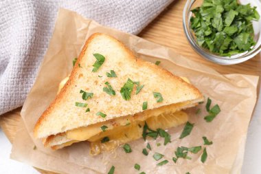 Eritilmiş peynirli ve maydanozlu lezzetli bir sandviç, yakın plan.