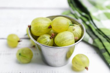 Olgun yeşil bektaşi üzümleri kasede beyaz ahşap masada, yakın plan.