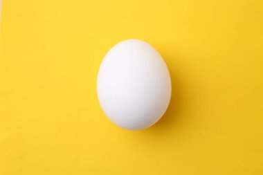 Sarı arka planda çiğ tavuk yumurtası.