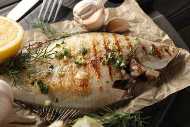 Ahşap masada servis edilen baharatlı kızarmış balık, yakın plan. Ev yapımı deniz ürünleri yemeği.