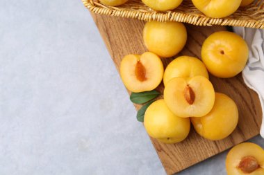 Gri masada, düz bir şekilde duran olgun sarı kiraz erikleri. Metin için boşluk