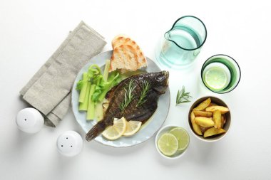 Beyaz masada servis edilen kerevizli kızarmış pisi balığı. Dümdüz. Ev yapımı deniz ürünleri yemeği.