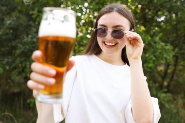 Bir bardak birası olan genç bir kadın.