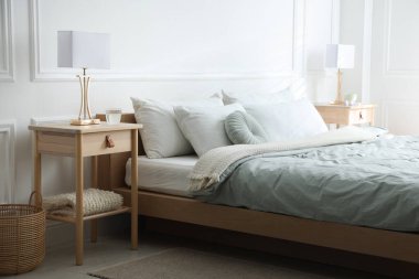 Yatağın yanında lambalar olan komodinlerin yanına.