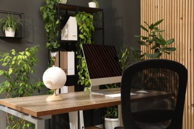 Biyofilik iç tasarım. Ofisinde bilgisayar ve ev bitkileri olan şık bir iş yeri