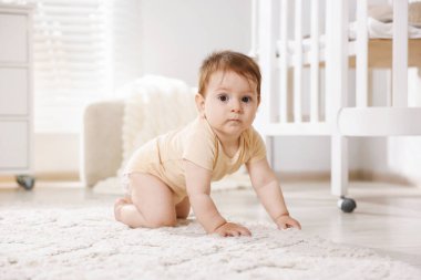 Odada yerde sürünen tatlı küçük bebek.