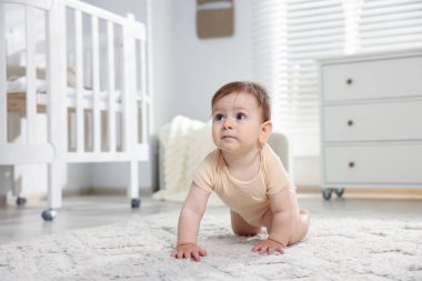 Odada yerde sürünen tatlı küçük bebek.