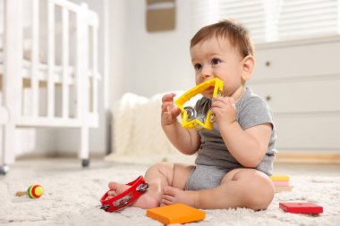 Odada oyuncaklarla oynayan şirin bir bebek.