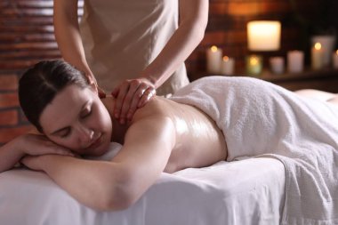 Spa salonunda kadın sırt masajı yaptırıyor.