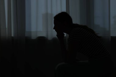 Evdeki üzgün genç kadının silueti. Metin için boşluk