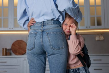 Küçük kız annesiz kalmaktan korkuyor ve evde ona sarılıyor. Ayrılık endişesi