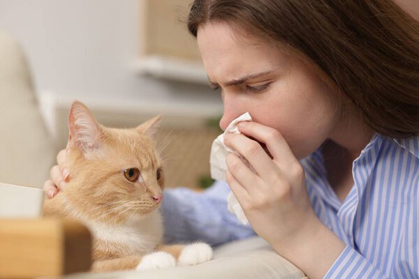 Женщина, страдающая аллергией с кошкой дома