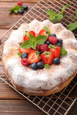 Tahta masada pudra şekeri ve böğürtlenli Lezzetli kek, yakın plan.