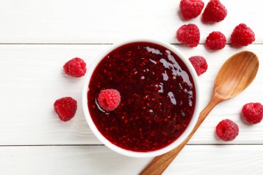 Tatlı ahududu reçeli kasede ve böğürtlen beyaz ahşap masada, düz yatıyordu.