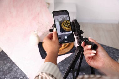 Stüdyoda lezzetli turta ve sütün fotoğrafını çeken bir kadın. Profesyonel yemek fotoğrafçılığı.