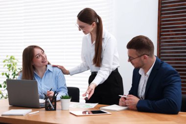 İşletme koçu ofiste insanlarla çalışıyor.