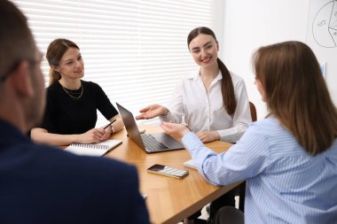 İş koçu ofisteki bir grup insana sunum yapıyor.