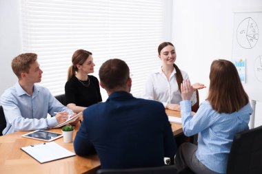 İş koçu ofisteki bir grup insana sunum yapıyor.