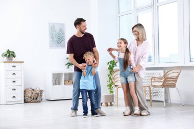 Mutlu aile aydınlık odada birlikte vakit geçiriyor.