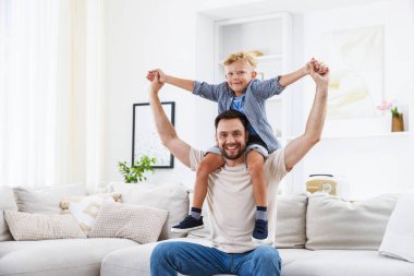 Mutlu baba ve oğlu evdeki kanepede birlikte vakit geçiriyorlar. Aile