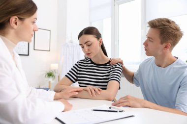 Tüp bebek (tüp bebek). Üreme kliniğine yaptığı ziyarette üzgün çifti destekleyen doktor