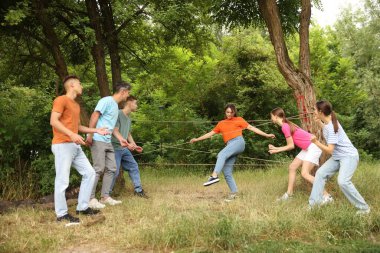 Takım oluşturma. Bir grup mutlu insan dışarıda örümcek ağı oynuyor.