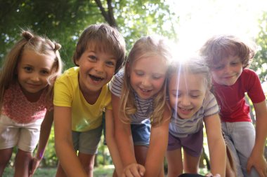 Sevimli küçük çocuklar parkta birlikte eğleniyorlar, düşük açılı.