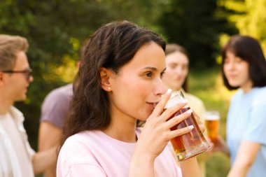 Bir grup mutlu arkadaş dışarıda bira içiyor ve eğleniyor.