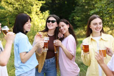 Bir grup mutlu arkadaş dışarıda bira içip eğleniyorlar.