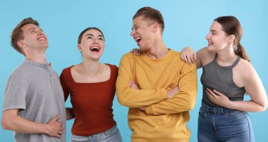 Açık mavi arka planda gülen arkadaşlar. Pozitif duygu