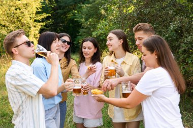 Bir grup mutlu arkadaş dışarıda bira içip eğleniyorlar.