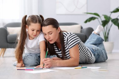 Anne ve kızı evdeki sıcak zeminde birlikte resim çiziyorlar. Isıtma sistemi