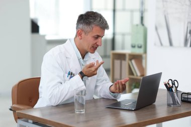 Teletıp. Doktor, bilgisayarla hastayla içeride görüntülü konuşma yapıyor.