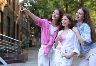 Şehir caddesinde birlikte yürüyen mutlu arkadaşlar.