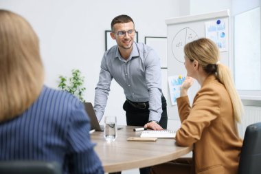 İş koçu ofisteki bir grup insana sunum yapıyor.