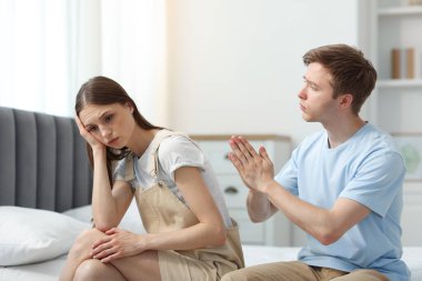 Adam evde yatağında gücenmiş sevgilisinden özür diliyor.