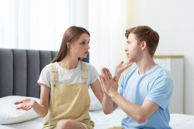 Bir erkek, evde yatarken karısından özür diliyor.