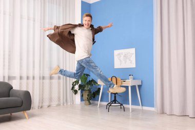 Eve atlayan mutlu genç adamın portresi.