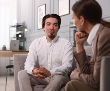 Meslektaşlar ofiste koltuklarda tartışıyorlar.