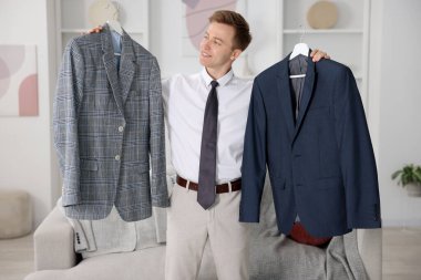 Hazırlanıyor. Genç adam evde kıyafet seçiyor.