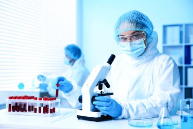 Tıbbi analiz. Laboratuvarda mikroskopla çalışan bilim adamı, seçici odaklanma