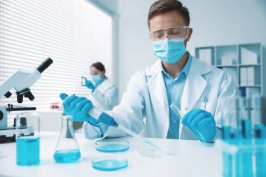 Tıbbi analiz. Laboratuvarda numuneyle çalışan bilim adamı, seçici odaklanma