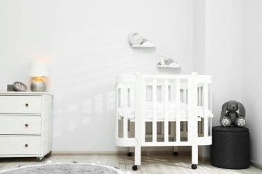 Rahat beşik ve diğer mobilyalarla dolu şık bir bebek odası.