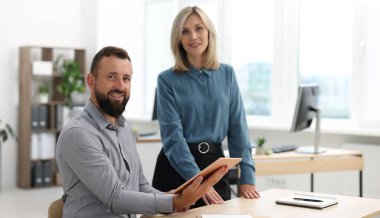 Ofiste tabletle gülümseyen iş ortaklarının portresi