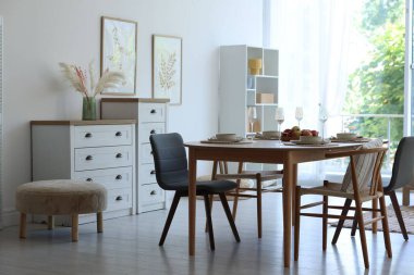 Yemek odasında güzel bir masa, sandalye ve dekor var. İç tasarım