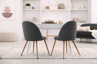 Süslü yemek odasında sandalyeli ve dekorlu beyaz bir masa. İç tasarım