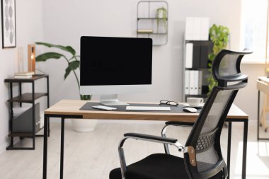 Ofisteki ahşap masada modern bilgisayarlı şık bir iş yeri.