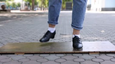 Step ayakkabılı genç kız dışarıda dans ediyor, yakın plan. Kamera aşağı iniyor